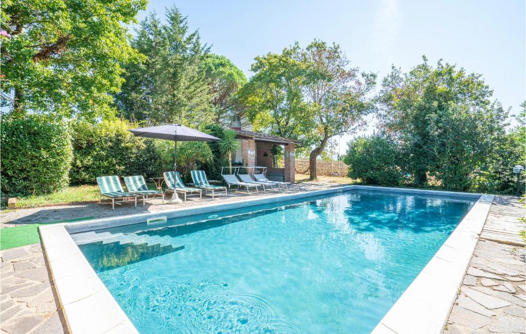una piscina con sillas y sombrilla en Le Vignacce, en Foiano della Chiana