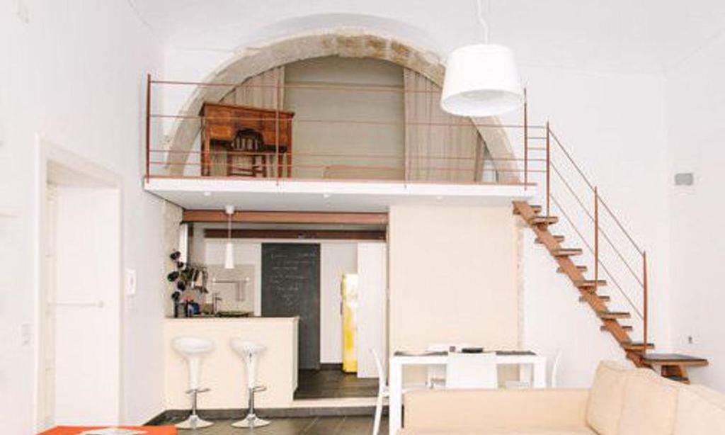 sala de estar con escalera y sofá en 1743 Loft, en Siracusa