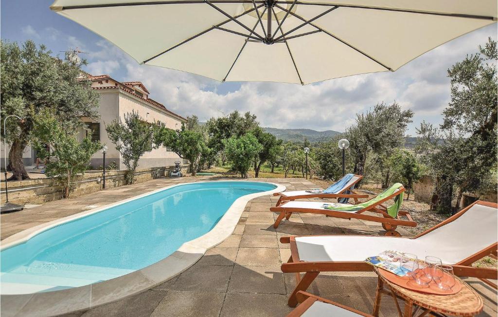 a swimming pool with chairs and an umbrella at Villa Odabella in Rongolisi