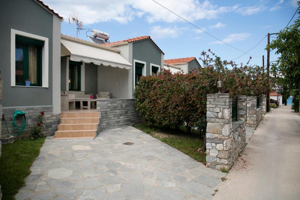 una casa con una pared de piedra junto a una acera en Arion Apartments en Skála Potamiás