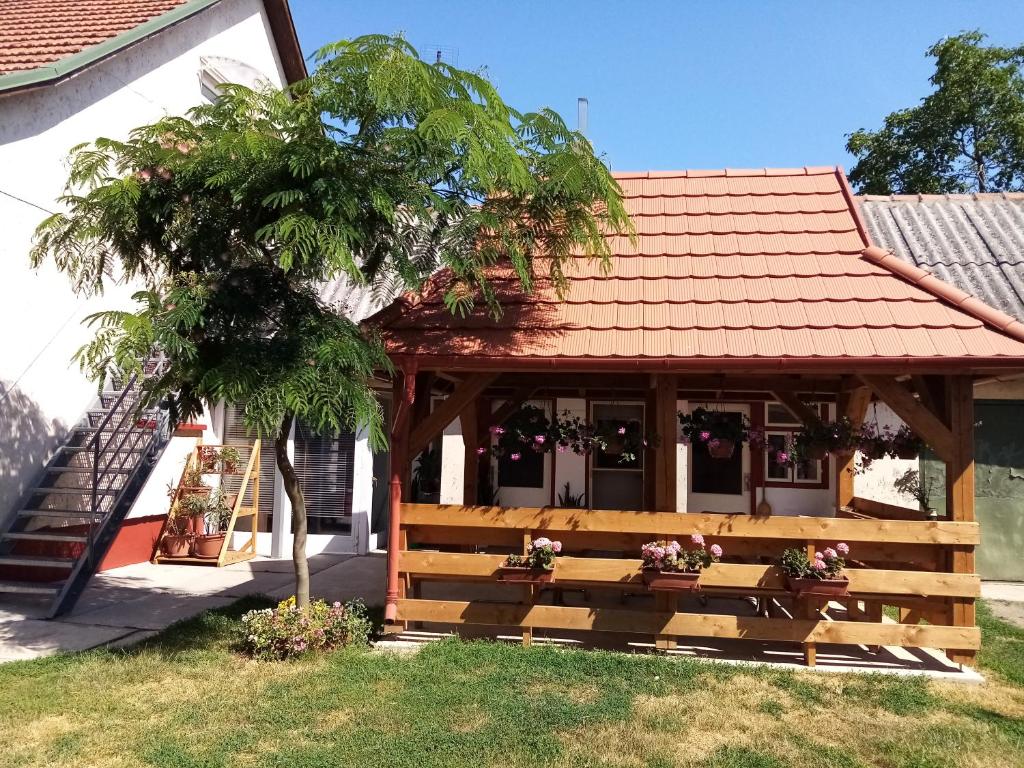 un banc en bois devant une maison dans l'établissement Mézeskuckó, à Tiszaszőlős