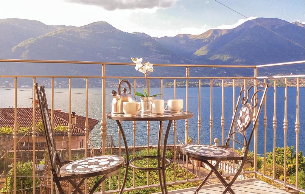 a table and chairs on a balcony with a view of the water at Pescau House in Lezzeno