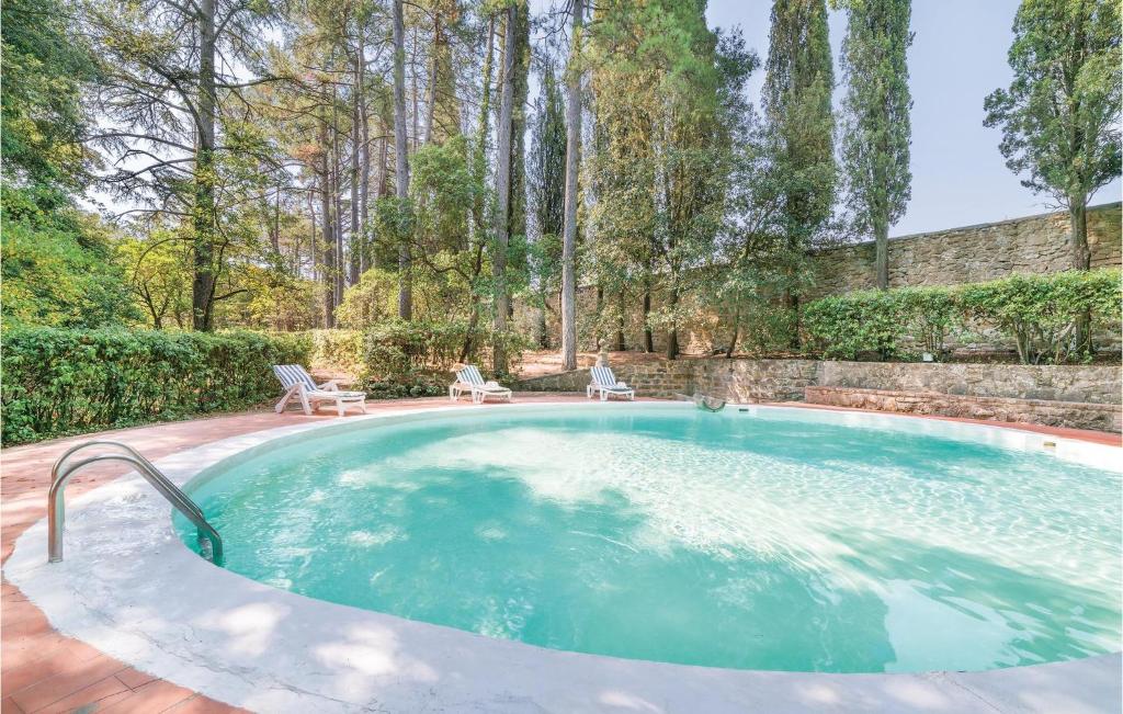 a large swimming pool in a yard with trees at Barbaiano C in Monte San Savino