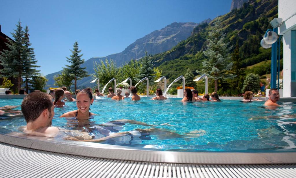 eine Gruppe von Personen in einem Schwimmbad in der Unterkunft Hotel Alpenblick-Leukerbad-Therme in Leukerbad