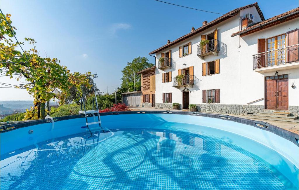 een zwembad voor een huis bij Cozy Home In Priocca With Kitchen in Priocca