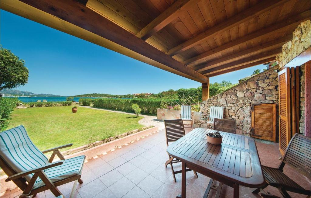eine Terrasse mit einem Tisch, Stühlen und einer Steinmauer in der Unterkunft Villa Rosalba in Olbia