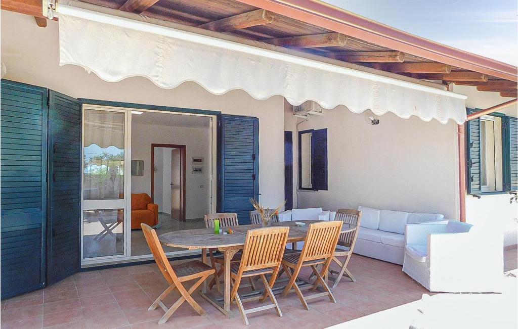eine Terrasse mit einem Tisch, Stühlen und einem Sofa in der Unterkunft Nice Home In Noto With House Sea View in Noto