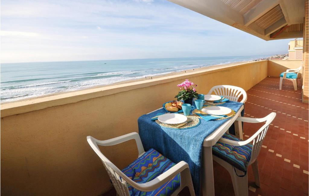 a table on a balcony with a view of the ocean at Gorgeous Apartment In Torvaianica in Torvaianica