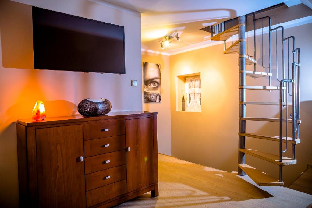 a living room with a staircase and a dresser with a television at Modern in Zgorzelec