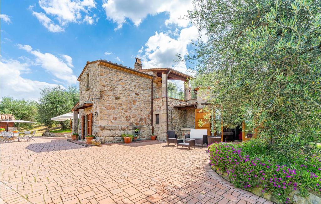 una casa de piedra con un patio frente a ella en La Selvarella, en Seggiano