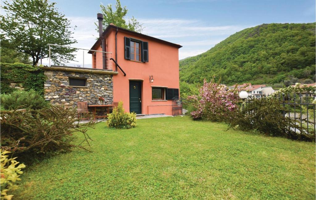 une maison avec une cour d'herbe devant elle dans l'établissement Casetta, à Pieve di Teco