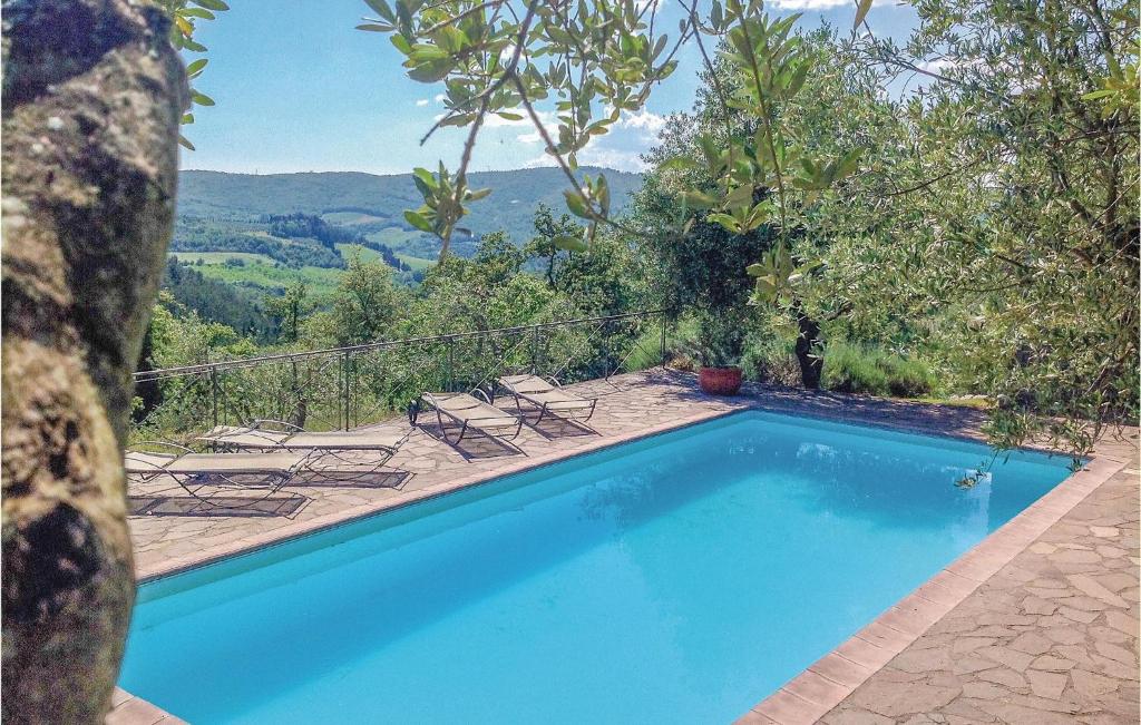 una piscina con sillas y vistas a las montañas en Poggione, en Gaiole in Chianti