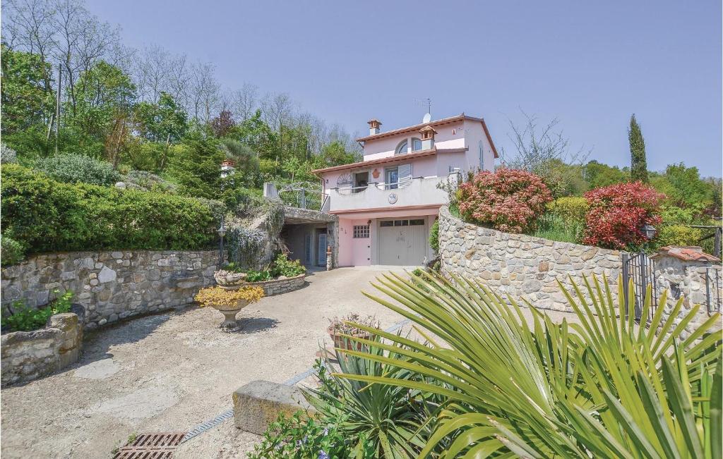 una casa con una pared de piedra y un camino de entrada en Casa Rosa, en Terranuova Bracciolini