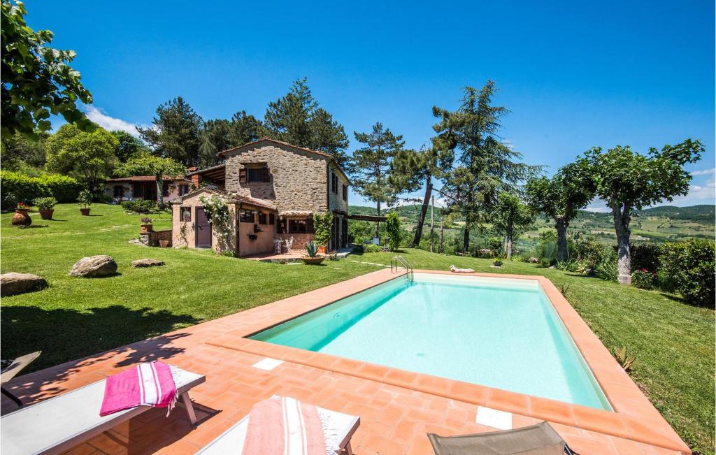 a swimming pool in a yard with a house at 2 Bedroom Gorgeous Home In Capolona in Capolona