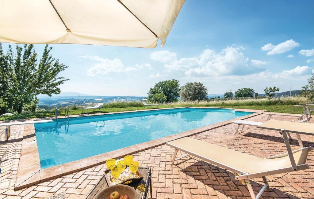 uma piscina com um pátio e um guarda-sol em Casale Di San Giorgio em Poggio