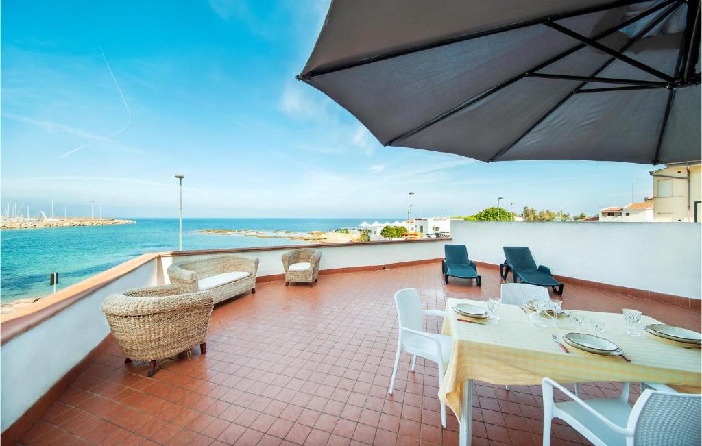 balcón con mesa, sillas y sombrilla en La Terrazza en Porto Torres