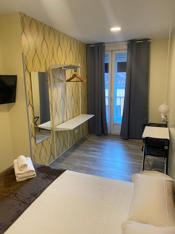 Un dormitorio con una cama y un piano en una habitación en Hostal Alaska, en Madrid