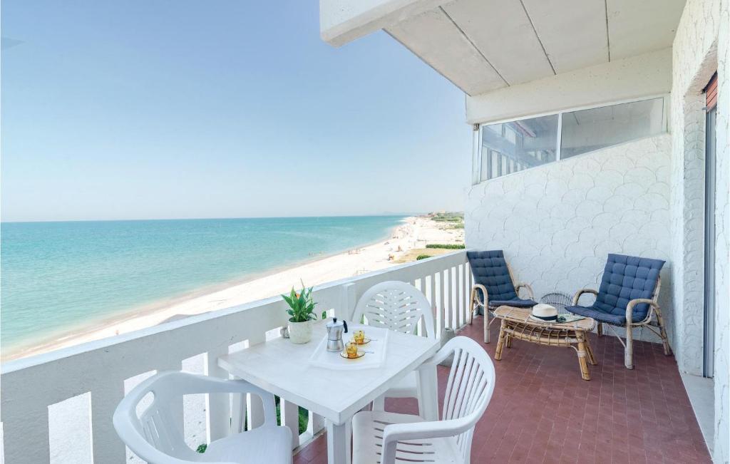 a white table and chairs on a balcony with the beach at Le Vele in Marotta