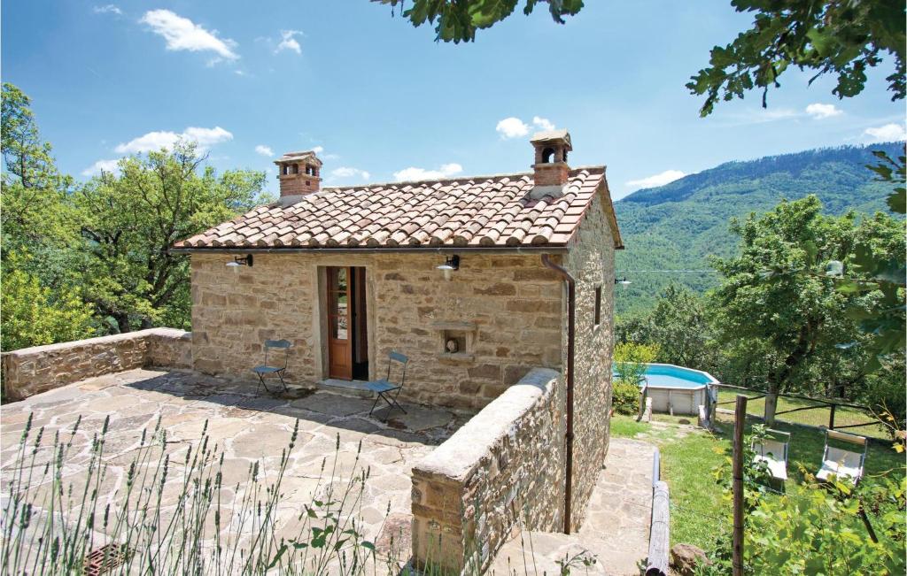 ein kleines Steinhaus mit einer Steinmauer in der Unterkunft 2 Bedroom Pet Friendly Home In Cortona Ar in Polvano