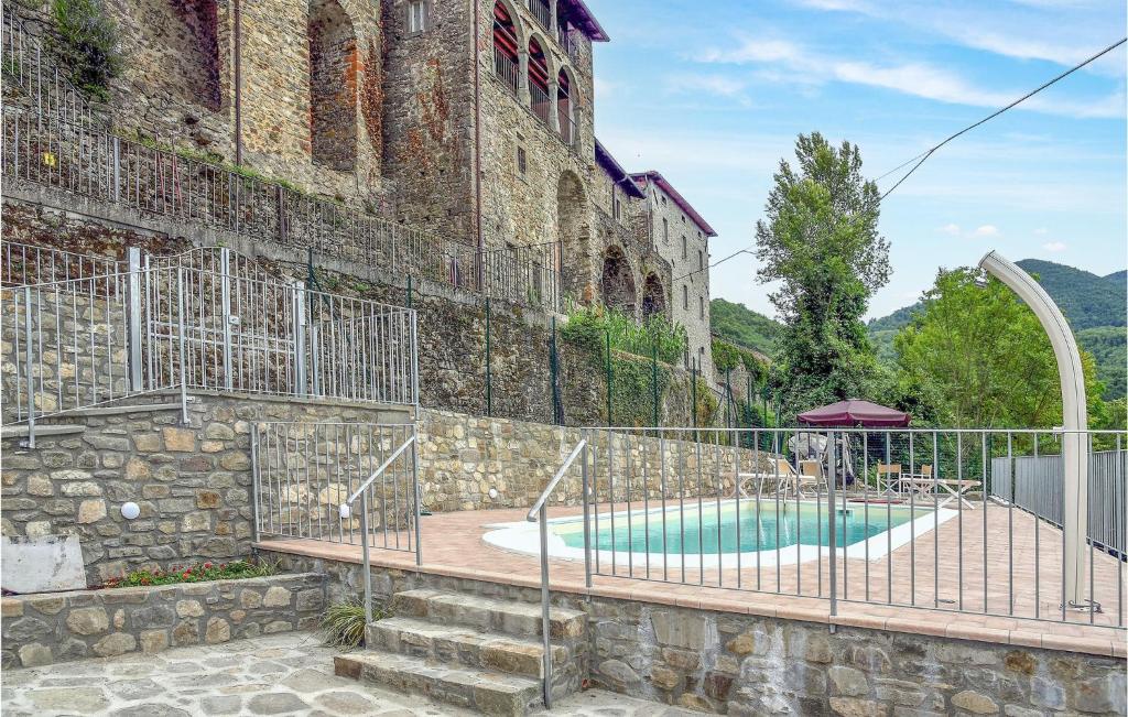 a building with a swimming pool in front of a building at Stunning Home In Nicciano With House A Panoramic View in Piazza al Serchio