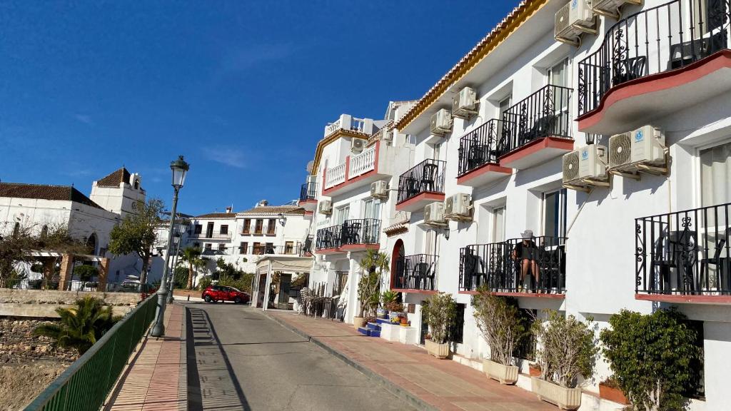 eine Straße in einer Stadt mit weißen Gebäuden in der Unterkunft Apartamentos Balcón de Maro in Maro