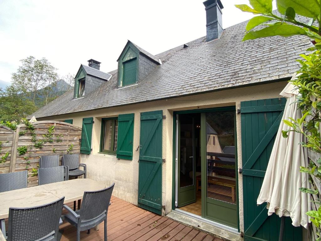 a patio with a table and chairs on a deck at Le 103. Chalet 3 chambres. Terrasse. Parking. wifi. in Cauterets