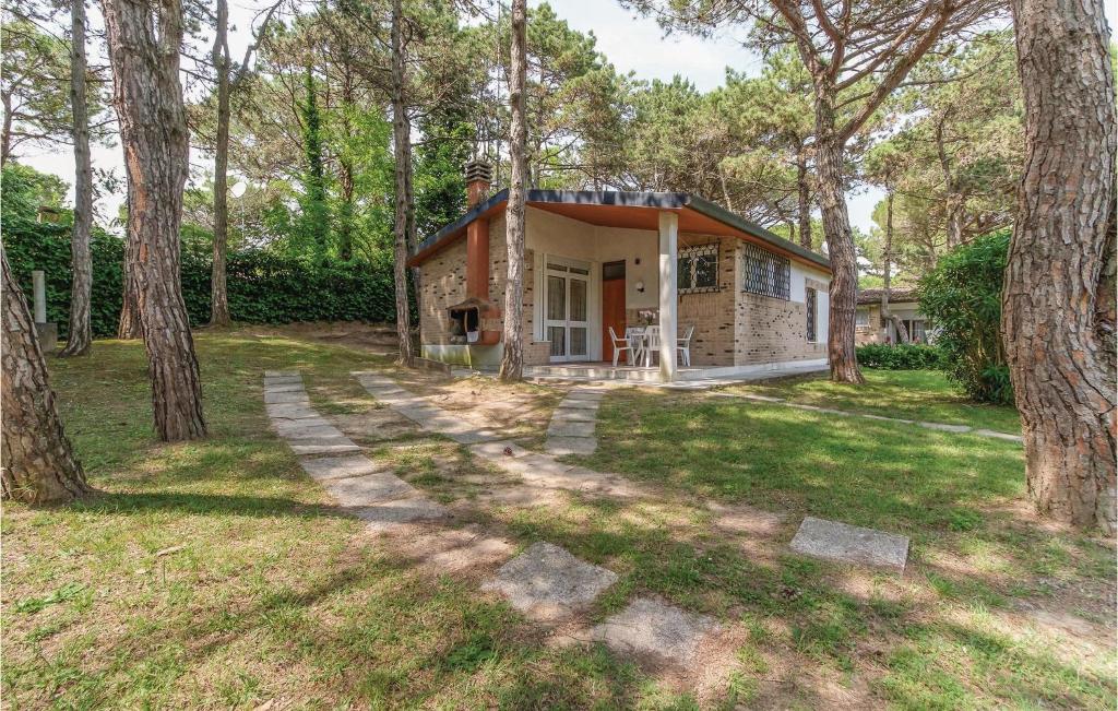 a small house in the woods with trees at Casa Laura 1 in Lignano Sabbiadoro