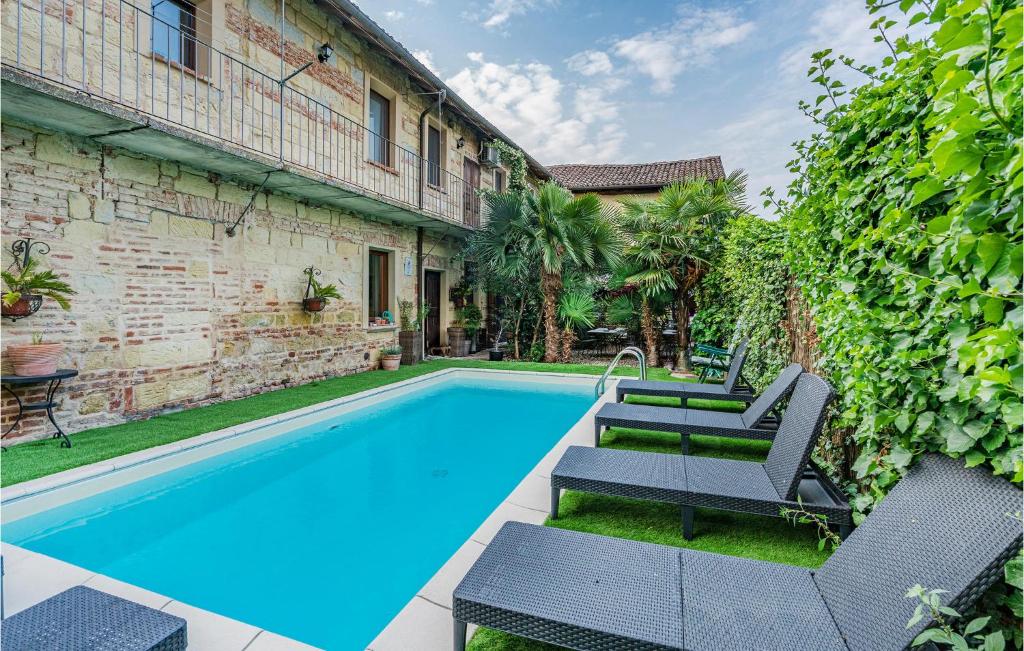 - une piscine avec des chaises longues à côté d'un bâtiment dans l'établissement Maison Des Reves, à Viarigi