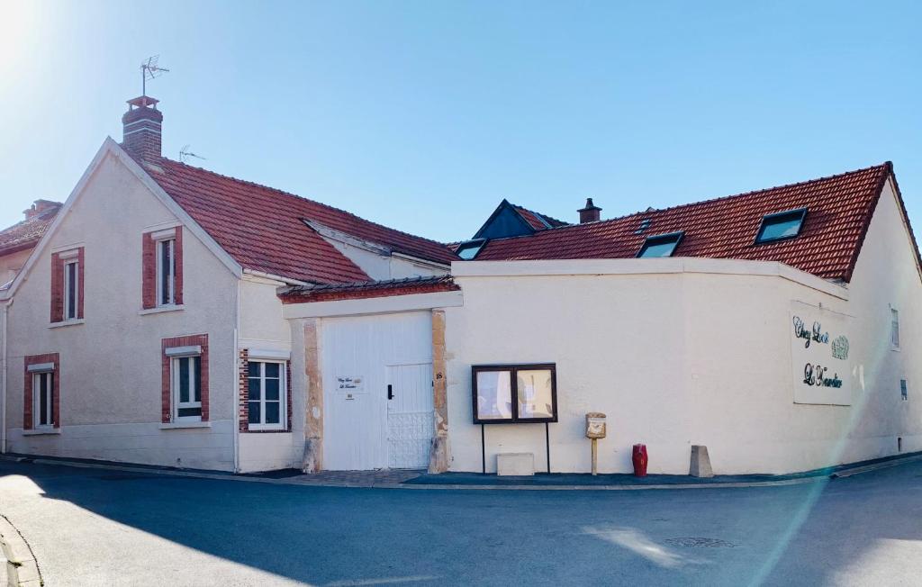 a large white building with a red roof at Gîte Chez Louis le Tonnelier Au coeur de la côte des Blancs in Le Mesnil-sur-Oger