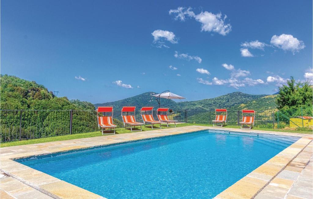 una piscina con sillas y un grupo de montañas en Casa Il Capriolo, en Sassalbo