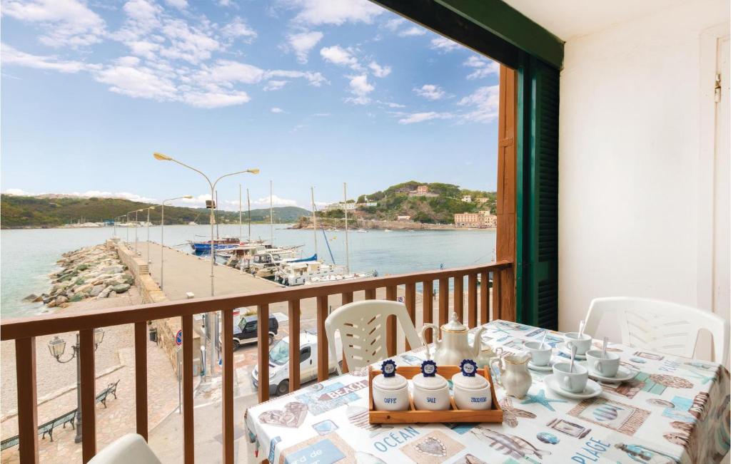 stół na balkonie z widokiem na wodę w obiekcie Casa Maddalena w mieście Porto Azzurro