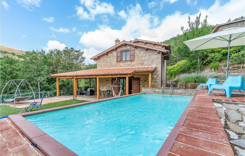 グッビオにあるAwesome Home In Gubbio -pg- With 2 Bedrooms And Outdoor Swimming Poolの家の前にスイミングプールがある家