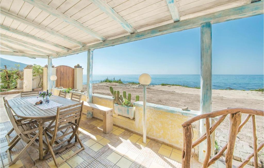 a patio with a table and chairs and the ocean at Casa In Riva Al Mare 2 in Castelsardo