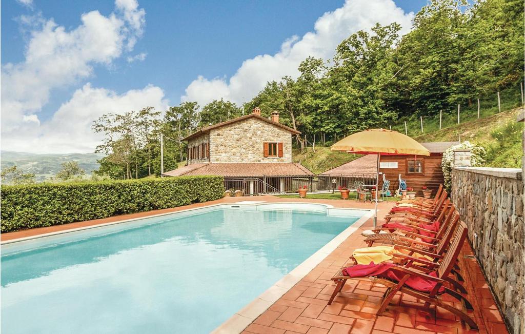 a swimming pool with chairs and a house at La Quiete in Moggiona