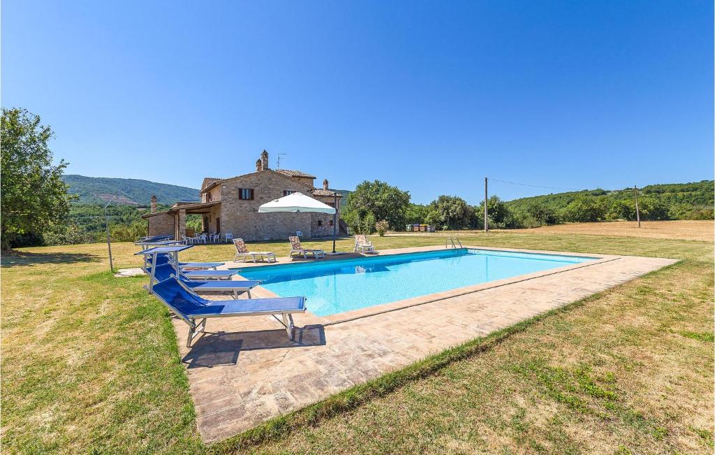 a swimming pool with chairs and a house at Portella in Saragano