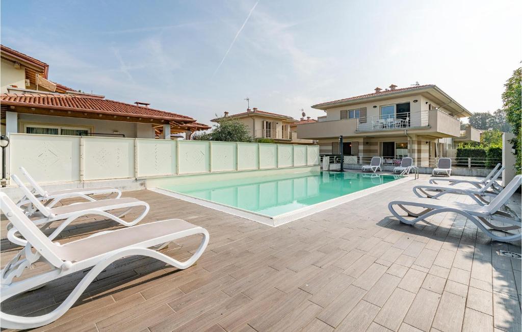 einen Pool mit Liegestühlen neben einem Haus in der Unterkunft Pet Friendly Apartment In Puegnago Sul Garda With Outdoor Swimming Pool in Raffa