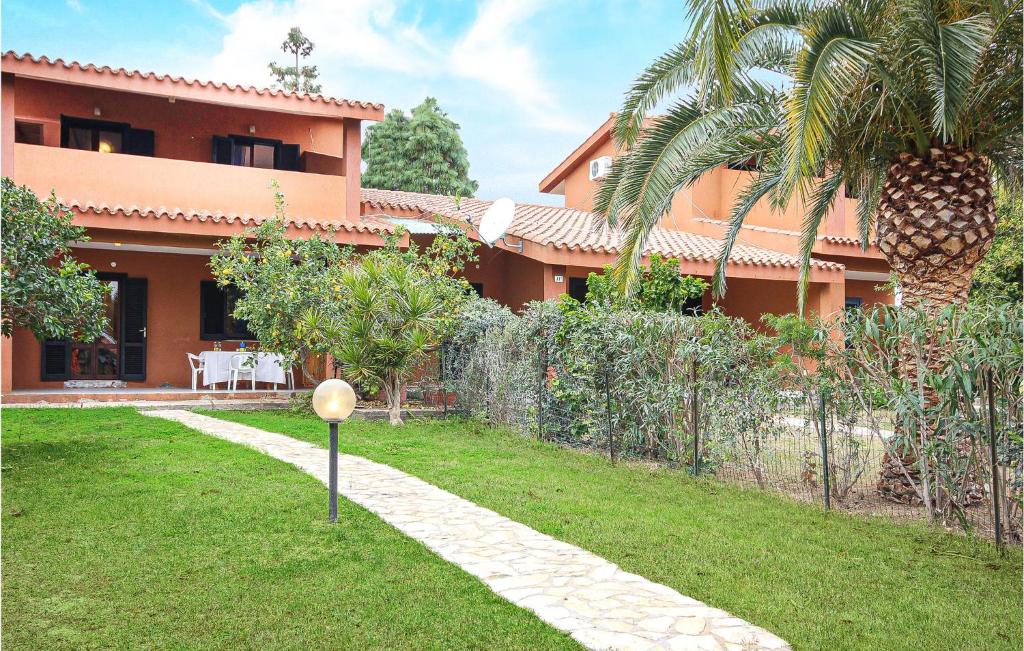 a garden in front of a house at 1 Bedroom Amazing Apartment In Costa Rei -Ca- in Costa Rei