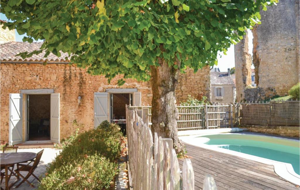 a tree in front of a house with a pool at Stunning Home In Sainte Alvre With 6 Bedrooms, Sauna And Private Swimming Pool in Saint-Alvère