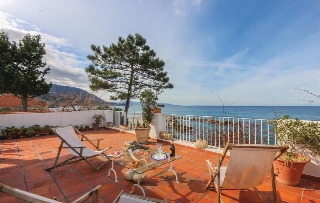 a patio with chairs and a view of the ocean at Villa Eugenia in Favazzina