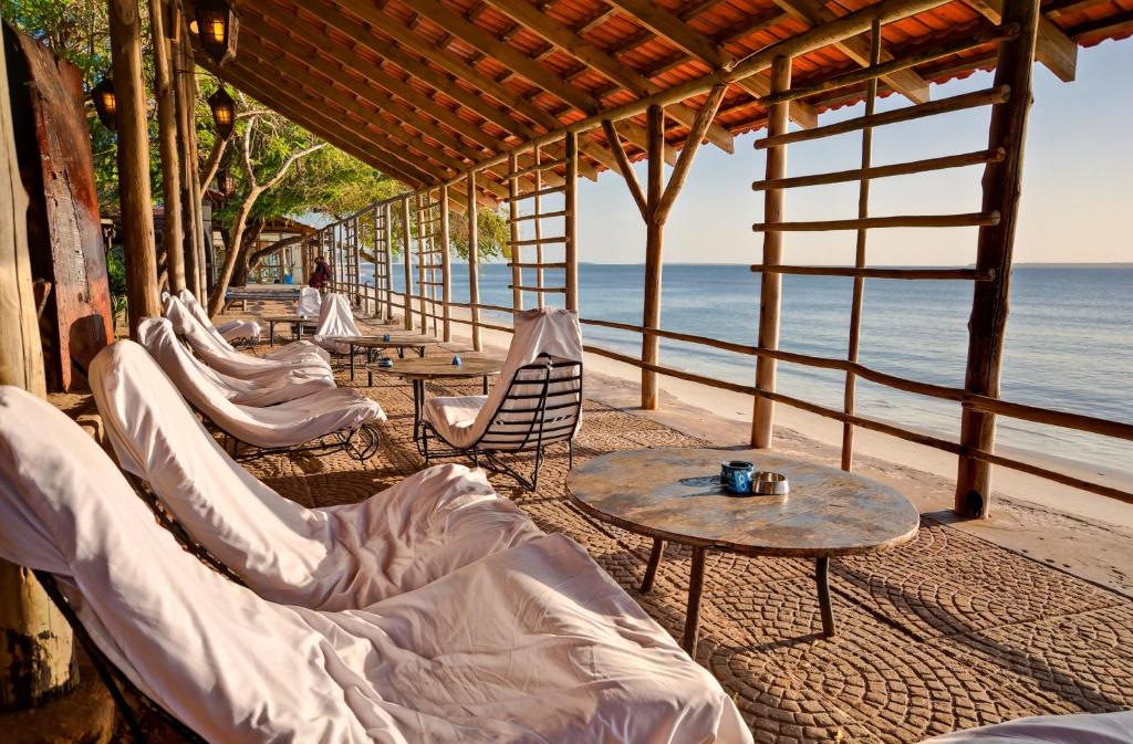 eine Reihe von Stühlen und Tischen am Strand in der Unterkunft Mediterraneo Boutique Hotel in Daressalam