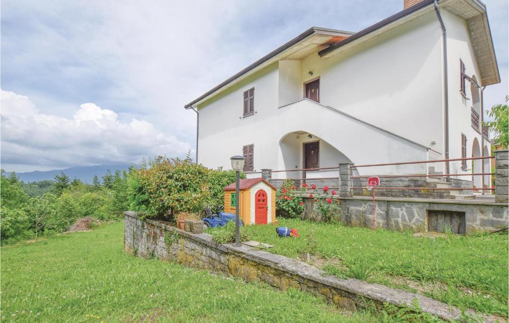 une maison blanche avec une porte rouge dans un champ dans l'établissement Casa Giovanni, à Tavarone