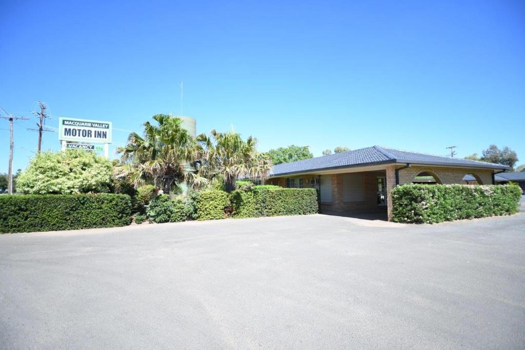 a house with a driveway in front of a building at Macquarie Valley Motor Inn in Warren