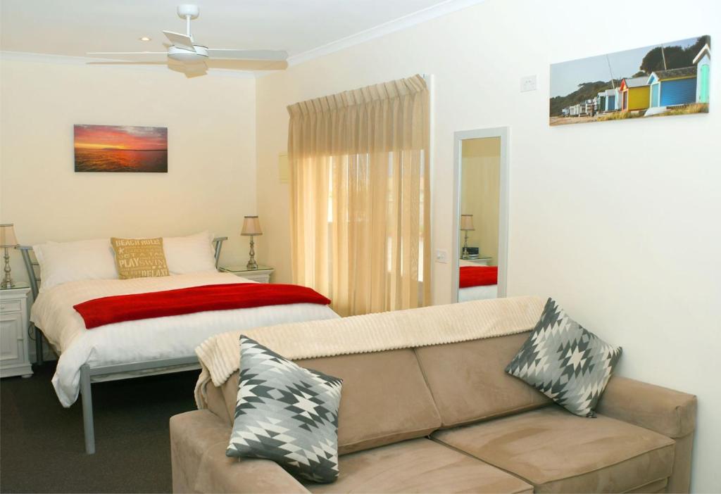 a living room with a couch and a bed at Dromana Beach Getaway in Dromana