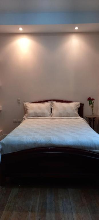 1 dormitorio con 1 cama con 2 luces en la pared en Villa del Rosario Hostal, en Cuenca