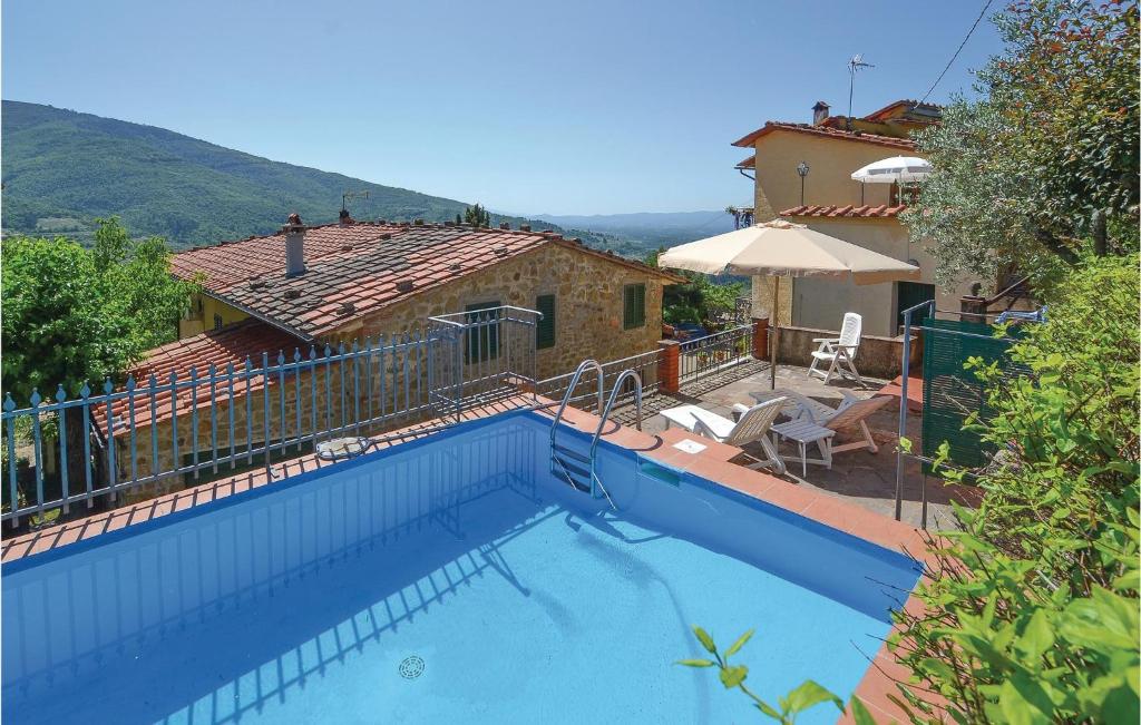 a large blue swimming pool in front of a house at Il Frantoio in Loro Ciuffenna