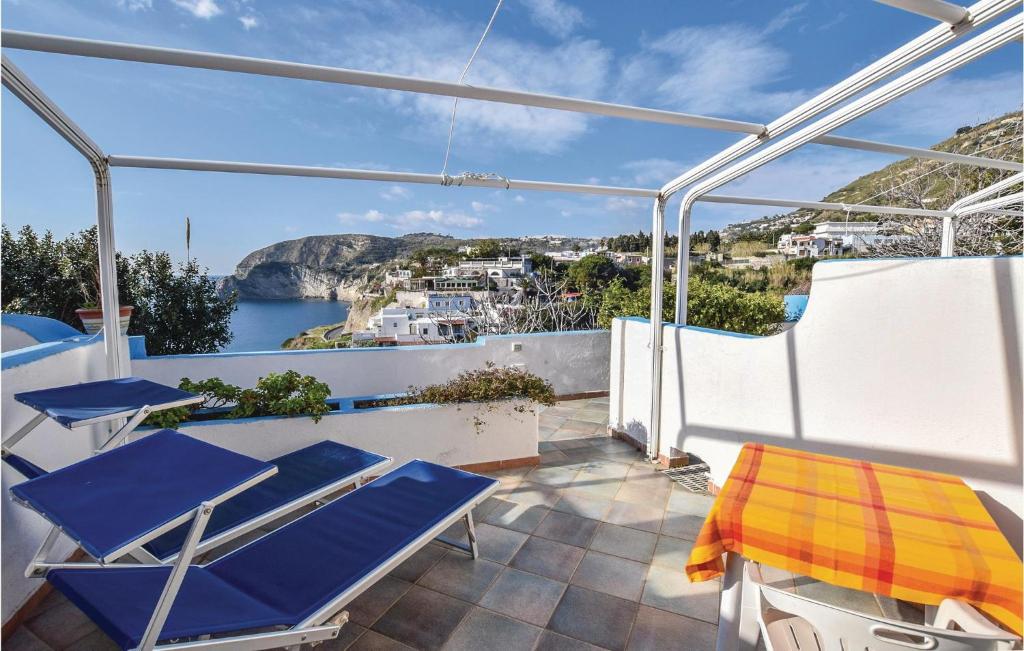 イスキアにあるStunning Apartment In Santangelo Dischia With House Sea Viewの水辺の景色を望むバルコニー(青い椅子付)