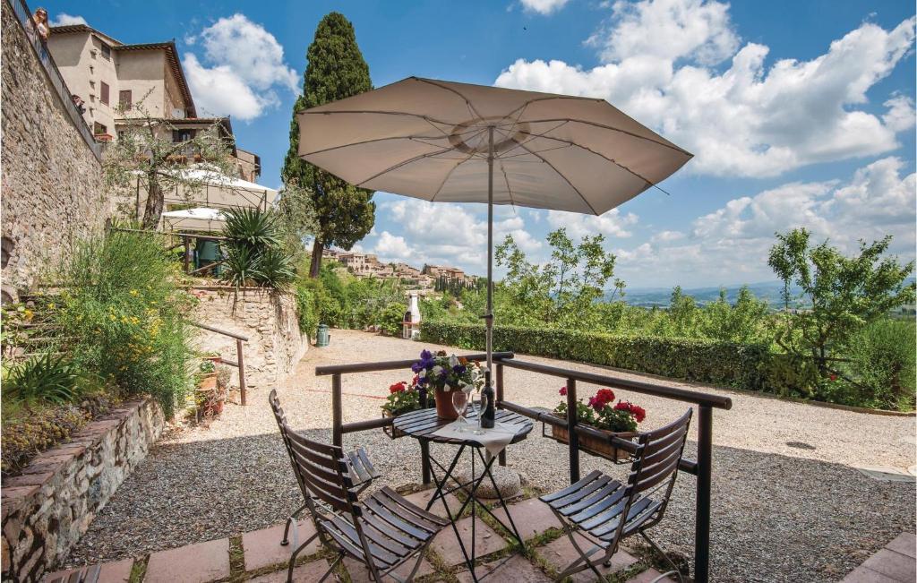 stół i dwa krzesła z parasolem w obiekcie Zafferano 3 w mieście San Gimignano