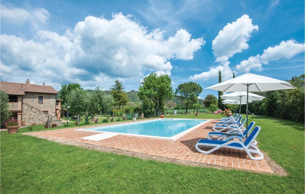 a group of chairs and an umbrella next to a pool at Cortilla 2 in Cinigiano