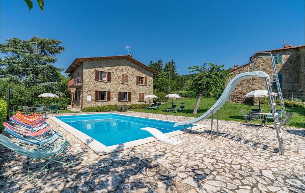 a swimming pool with a slide in front of a house at Gorgeous Apartment In Cortona Ar With Wifi in Poggioni