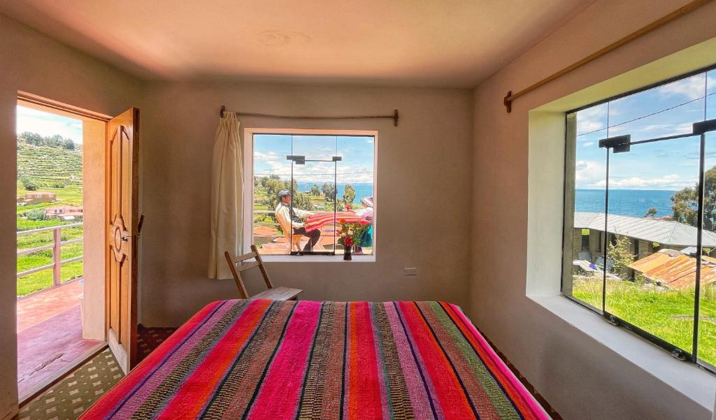 a bedroom with a bed and a large window at Richar’s home - experience Amantani with my family in Ocosuyo